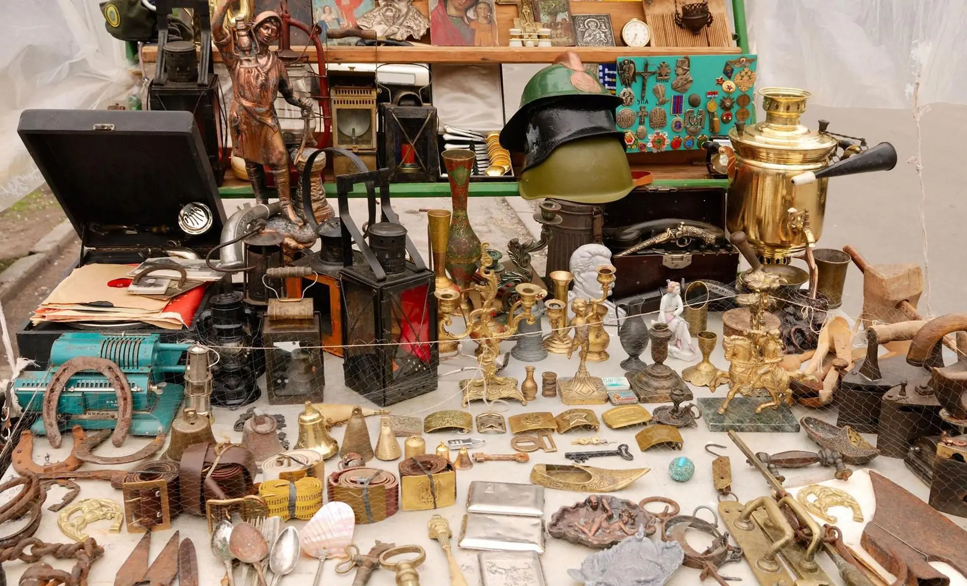 Table of vintage collectibles, brassware, militaria, and curios