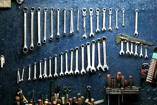 Rows of combination wrenches and pliers hanging on a workshop pegboard