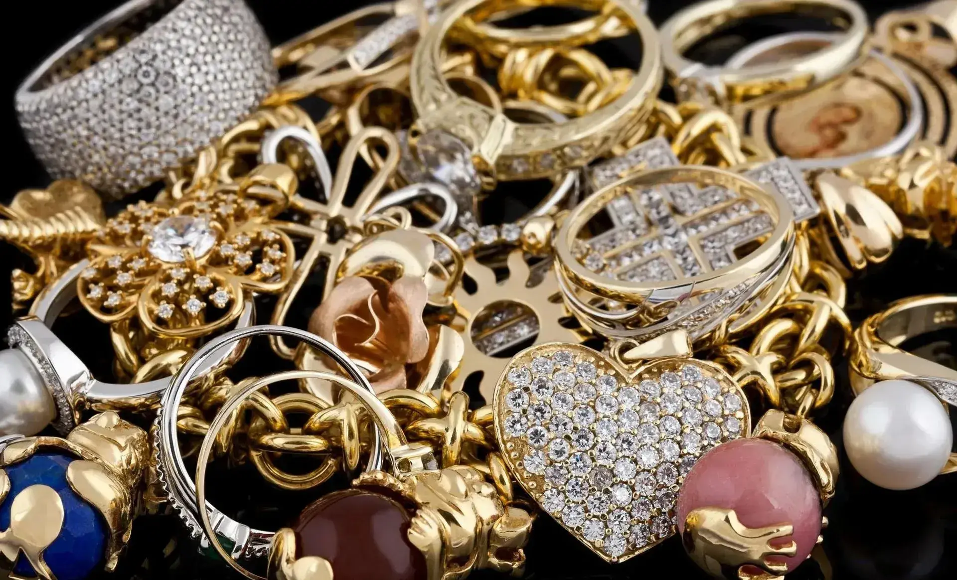 Pile of gold and diamond rings, pendants, and pearl jewelry